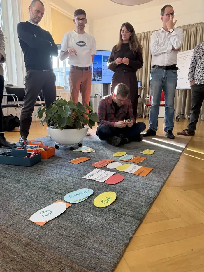 Teilnehmende erproben eine Teamcoaching-Methode mit Karten am Boden in Modul 11 der Coaching-Ausbildung Leipzig